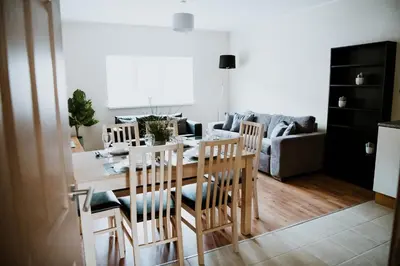 a kitchen and living room with a table and chairs at Flats near football clubs in Liverpool