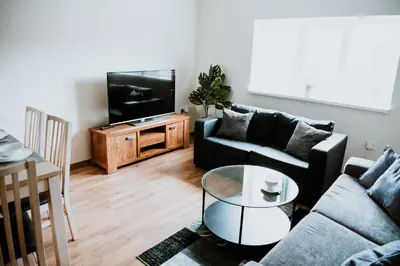 a living room with a couch and a tv at Flats near football clubs in Liverpool