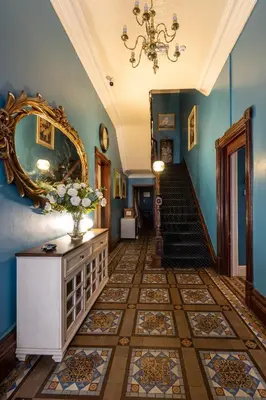 a hallway with blue walls and a staircase with a mirror at BEACH VIEW - Amazing Sea Views in Lytham St Annes