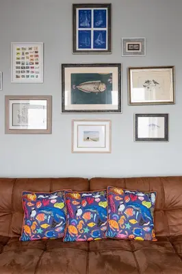 a couch in a living room with pictures on the wall at BEACH VIEW - Amazing Sea Views in Lytham St Annes