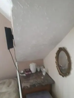 a small room with a mirror and a bed at Witton house in Blackpool