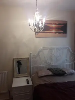 a bedroom with a bed with a mirror and a chandelier at Witton house in Blackpool