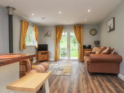 a living room with a couch and a table at Park Brook Dell in Preston