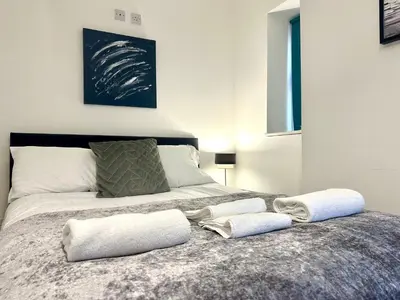 a bed with two towels on top of it at Sienna Family Holiday Apartments by Blackpool Service Apartments in Blackpool