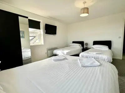a room with two beds and a mirror at Sienna Family Holiday Apartments by Blackpool Service Apartments in Blackpool
