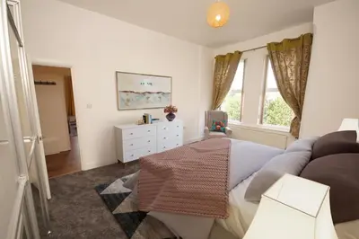 a bedroom with a bed and a dresser and a window at Grosvenor Lodge Birkdale Southport in Southport