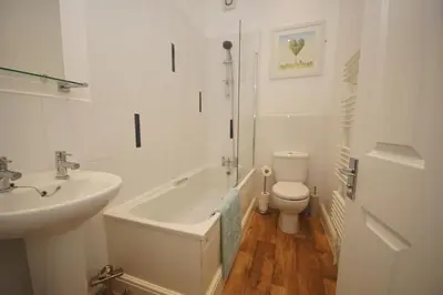 a white bathroom with a sink and a toilet at Grosvenor Lodge Birkdale Southport in Southport