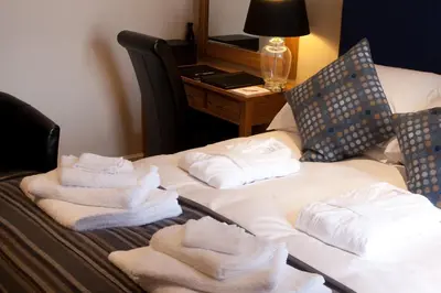 a hotel room with towels on a bed with a desk at Langtrys in Blackpool
