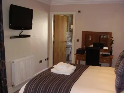 a hotel room with a bed with a television on the wall at Langtrys in Blackpool