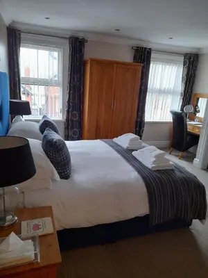 a hotel room with a large bed and a desk at Langtrys in Blackpool
