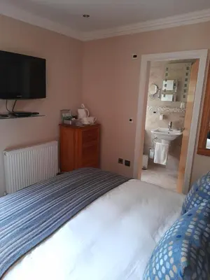 a bedroom with a bed and a bathroom with a sink at Langtrys in Blackpool
