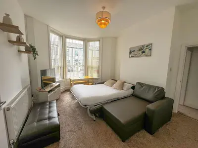 a bedroom with a bed and a couch and a chair at Cherry Property - Pear Suite in Blackpool