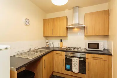 a kitchen with a sink and a stove top oven at Cherry Property - Pear Suite in Blackpool