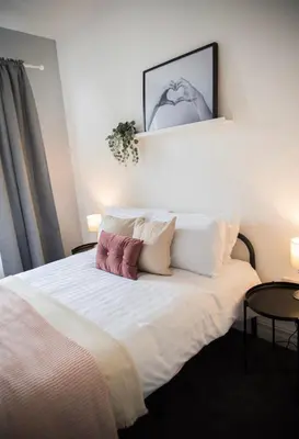 a bedroom with a large white bed with pillows at Buchanan House Sasco Apartments in Blackpool