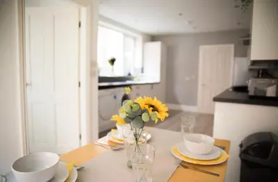 a kitchen with a table with a vase of flowers on it at Buchanan House Sasco Apartments in Blackpool