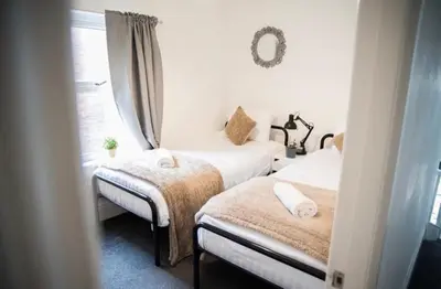 a bedroom with two beds and a window at Buchanan House Sasco Apartments in Blackpool