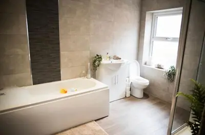 a bathroom with a tub and a sink and a toilet at Buchanan House Sasco Apartments in Blackpool