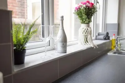 a window sill with wine glasses and flowers on it at Buchanan House Sasco Apartments in Blackpool