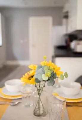 a vase filled with yellow flowers sitting on a table at Buchanan House Sasco Apartments in Blackpool
