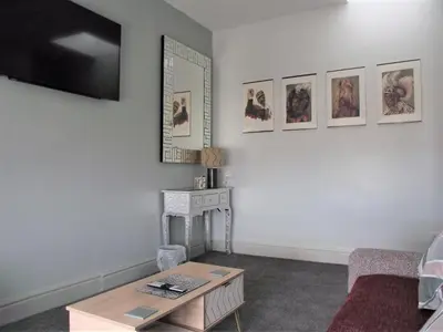 a living room with a coffee table and pictures on the wall at Seahawk Holiday Apartments in Cleveleys