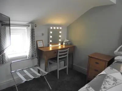 a bedroom with a desk with a chair and a window at Seahawk Holiday Apartments in Cleveleys