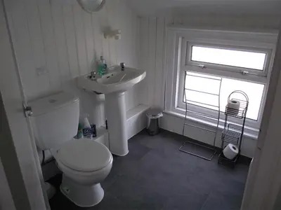 a bathroom with a toilet and a sink and a window at Seahawk Holiday Apartments in Cleveleys