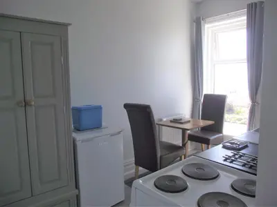 a kitchen with a stove and a table with chairs at Seahawk Holiday Apartments in Cleveleys