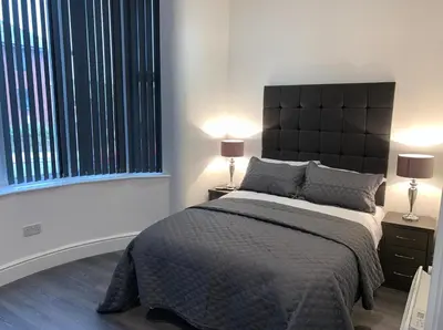 a bedroom with a large bed and two lamps at Albert Hottub & Jacuzzi Apartments in Blackpool