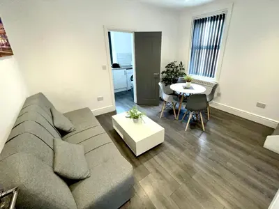 a living room with a couch and a table at Albert Hottub & Jacuzzi Apartments in Blackpool