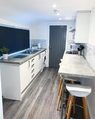 a kitchen with white cabinets and a counter top at Albert Hottub & Jacuzzi Apartments in Blackpool
