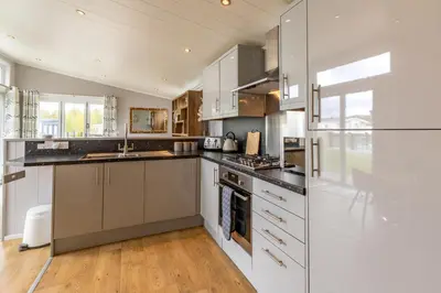 a kitchen with white cabinets and a stove top oven at Inside No. 1 Retreat in Carnforth
