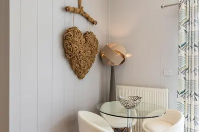 a glass table in a room with a heart on the wall at Inside No. 1 Retreat in Carnforth