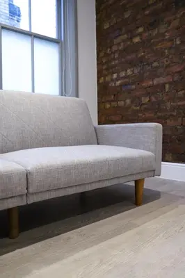 a couch in a living room with a brick wall at 16 Queen Avenue Collection by Happy Days in Liverpool