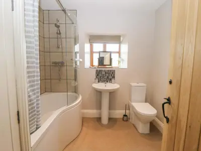 a bathroom with a tub and a sink and a toilet at Cuthbert Hill Farm in Preston