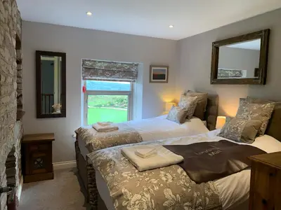 a bedroom with two beds and a window at Cuthbert Hill Farm in Preston