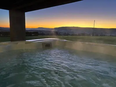 a hot tub with the sunset in the background at Cuthbert Hill Farm in Preston