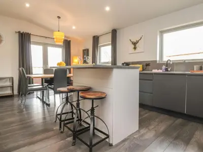 a kitchen with a bar and a table with stools at Box Tree Escapes in Lancaster
