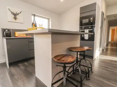 a kitchen with a counter and two stools at Box Tree Escapes in Lancaster