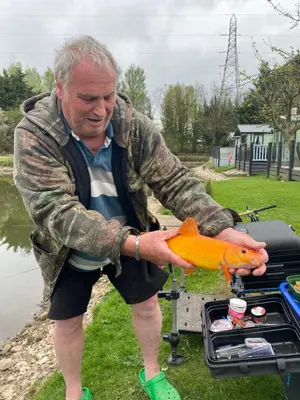 a man holding a fish in front of a grill at lake view staycations in Carnforth