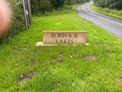 a sign on the side of a road at lake view staycations in Carnforth