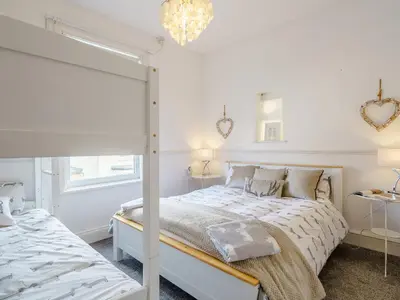 a white bedroom with a bed and a mirror at The Kings Landing Spa in Blackpool