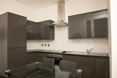 a kitchen with brown cabinets and a sink at Lord Street Apartments By Happy Days in Liverpool