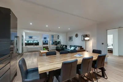 a living room and dining room with a table and chairs at Lord Street Apartments By Happy Days in Liverpool