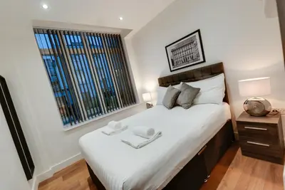 a bedroom with a large bed and a window at Lord Street Apartments By Happy Days in Liverpool