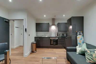 a living room with a couch and a kitchen at Lord Street Apartments By Happy Days in Liverpool