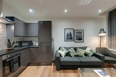 a living room with a couch and a kitchen at Lord Street Apartments By Happy Days in Liverpool