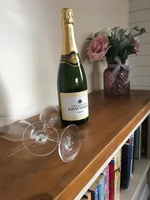 a bottle of champagne and a glass on a table at Keer Side Lodge, Luxury lodge with private hot tub at Pine Lake Resort in Carnforth