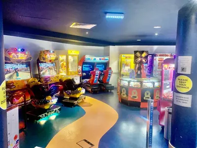 a room with arcade games and video game machines at Keer Side Lodge, Luxury lodge with private hot tub at Pine Lake Resort in Carnforth