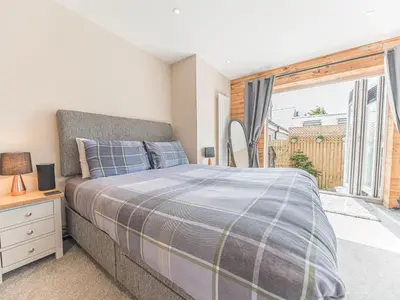 a bedroom with a bed and a large window at The Lodge in Dalton in Furness