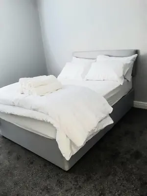 a large white bed with white sheets and pillows at Hanwell House in Liverpool